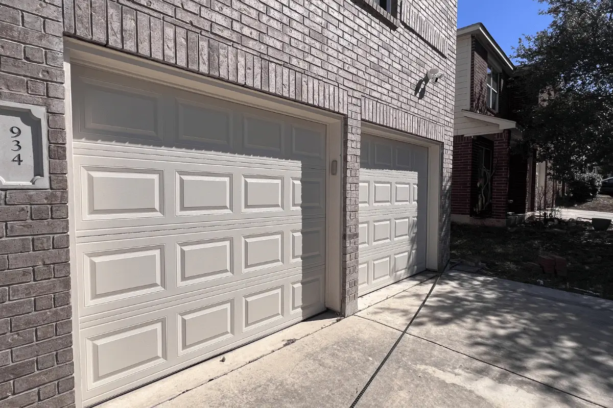 Almond CHI short raised-panel garage door after replacement